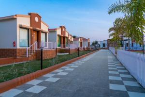 an empty street with houses and palm trees at Flamingo Club and Resort Una 3 Km Away from Diu Check Post in Diu