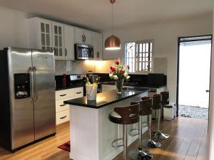 a kitchen with a stainless steel refrigerator and bar with stools at Casa Ozuna in Mendoza