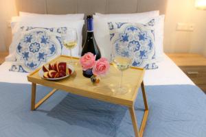 卡西奧皮的住宿－Pelagia Apartment by Kormaris，床上的桌子,上面放着酒杯和一碗水果