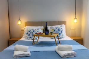 卡西奧皮的住宿－Pelagia Apartment by Kormaris，一张带桌子的床铺,配有一瓶酒和一杯葡萄酒