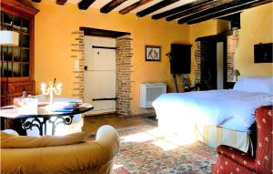 een slaapkamer met een bed, een tafel en een bank bij Nice Home In Conflans Sur Anille With Kitchen in Conflans-sur-Anille