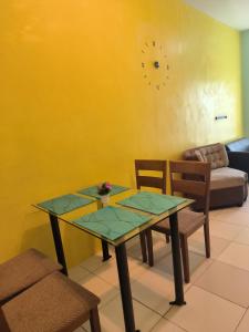 - une salle à manger avec une table, des chaises et un canapé dans l'établissement Alabang Condominium PHC, à Manille