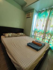 ein Schlafzimmer mit einem Bett mit zwei Handtüchern darauf in der Unterkunft Alabang Condominium PHC in Manila
