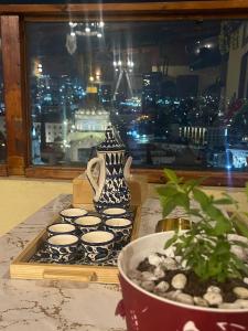 un groupe de tasses de thé et un vase sur une table dans l'établissement Seedi Yousef Hostel & Cafe, à Nazareth