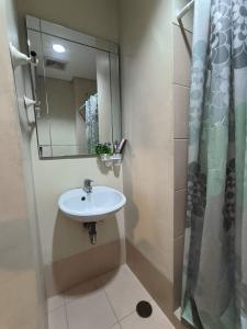 y baño con lavabo y espejo. en Alabang Condominium PHC en Manila