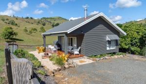 a small house with two chairs and a fence at Country Mile Escape in Canungra