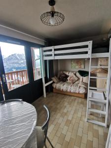 a bedroom with a bunk bed and a table and a table and chairs at Studio vue montagne proche des pistes in Orcières