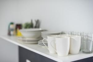a row of white cups and plates on a counter at City Stroll in Athens