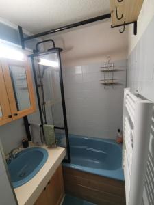 a bathroom with a blue tub and a sink at Studio vue montagne proche des pistes in Orcières