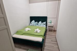1 dormitorio con 1 cama con sábanas y almohadas verdes en Damjanich 51- Lovely 3bedroom apartment en Budapest