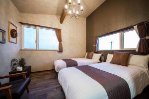 two beds in a room with two windows at Yadoya YADOKARI in Pippu