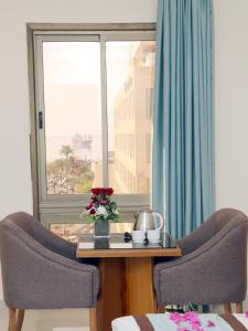 a table with two chairs in front of a window at Al Raad Hotel in Aqaba