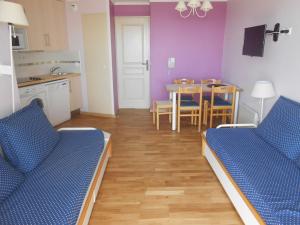 Una cocina y un comedor con dos sofás azules y una mesa. en AGAY, Cap Esterel, magnifique vue mer panoramique et Esterel, terrasse, piscines, parking, dernier étage, 3 étoiles, en Saint-Raphaël