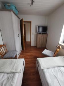 a room with two beds and a flat screen tv at Zur langen Heide in Hildburghausen