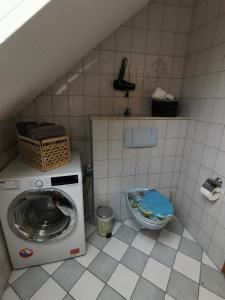 a small bathroom with a washing machine and a toilet at Zur langen Heide in Hildburghausen +20 photos