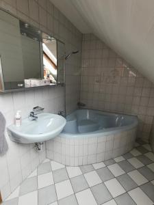 een badkamer met een bad, een wastafel en een spiegel bij Zur langen Heide in Hildburghausen