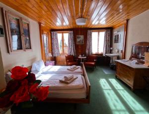 a bedroom with two beds and a wooden ceiling at Edelweiss Lodge in Wilderswil