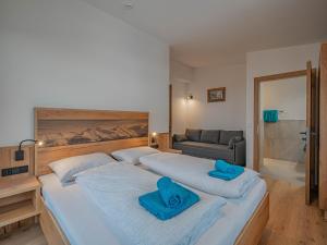 1 dormitorio con 2 camas y toallas azules. en Appartement Andrea Cäciel en Brixen im Thale