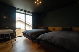 1 dormitorio con 2 camas, escritorio y ventana en Awaji-shima C-Side Marine Terrace - Vacation STAY 88860v en Minamiawaji