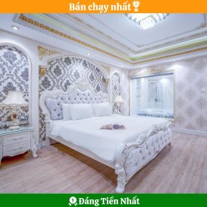 een slaapkamer met een groot wit bed in een kamer bij Royal Beach Hotel by THG in Da Nang
