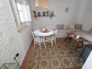 - un salon avec une table, des chaises et un canapé dans l'établissement Casa Al-Janda, à Barbate