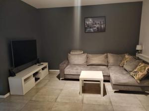a living room with a couch and a flat screen tv at Apartament Krucze Łąki in Kruklanki