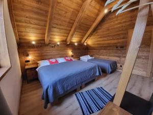 1 Schlafzimmer mit 2 Betten in einer Holzhütte in der Unterkunft Hillview Jasná Chalet in Demänovská Dolina