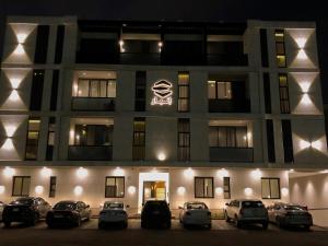 hotel z samochodami zaparkowanymi przed nim w nocy w obiekcie Inbar Residence إنبار ريزدينس شقة عائلية متكاملة w Rijadzie
