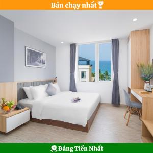 een slaapkamer met een bed, een bureau en een raam bij Davue Hotel by THG in Da Nang