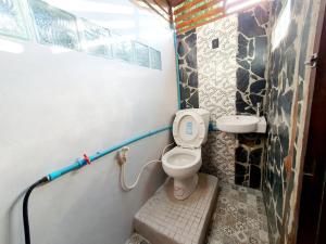 a small bathroom with a toilet and a sink at Baan Suan Taboon Homestay in Chiang Rai