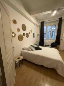 een slaapkamer met een groot wit bed in een kamer bij LA GRANDE COTE in Lyon
