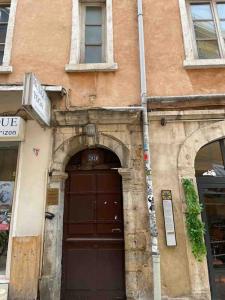 een oud gebouw met een grote deur ervoor bij LA GRANDE COTE in Lyon