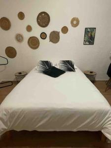 een wit bed in een kamer met borden aan de muur bij LA GRANDE COTE in Lyon