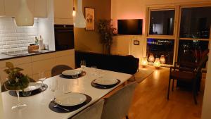 einen Esstisch mit Tellern und Weingläsern darauf in der Unterkunft Exclusive Waterfront Apartment - 12th Floor in Kopenhagen