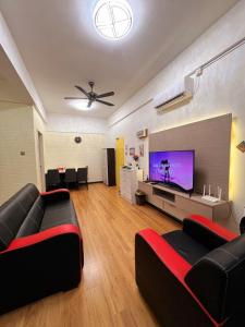 salon z 2 kanapami i telewizorem z płaskim ekranem w obiekcie KW HOMESTAY CASA UNO APARTMENT w mieście Sandakan
