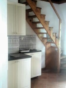 a kitchen with white cabinets and a staircase at VÁRBALOG in Várbalog