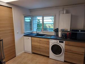 a kitchen with a washing machine and a sink at Cosy Appartement near Disneyland & Paris in Coupvray