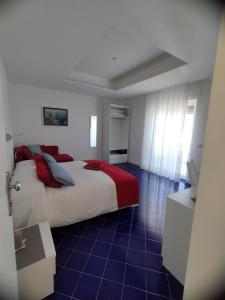 a bedroom with a large bed with red and blue pillows at Domus Sole in Sorrento