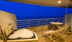 a balcony with a tub and a table on a ship at Sandy Beach E18 in Cha Am