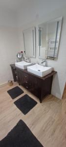 Le Mas de la Rocherie Chambre d'hôtes "Référence" في Pihen-lès-Guînes: حمام به مغسلتين ومرآة كبيرة
