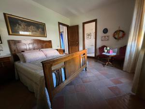 1 dormitorio con 1 cama grande de madera y 1 silla en A casa di Giò, en Fuscaldo
