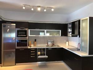 a kitchen with black cabinets and stainless steel appliances at Peramos Luxury in Nea Peramos