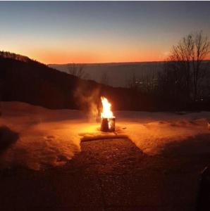 eine Feuerstelle im Schnee bei Sonnenuntergang in der Unterkunft On the hill in Sasbachwalden
