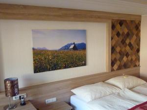 a bedroom with a bed and a painting on the wall at Glätzle`s Ferienhaus in Zöblen