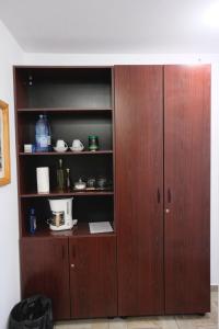 a wooden cabinet with a coffee maker in it at Solomon Apartments Room nr 5 in Sângeorgiu de Mureș