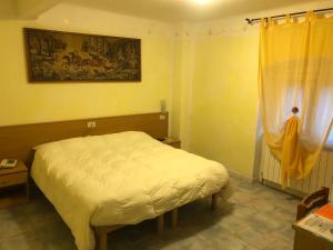 a bedroom with a white bed and a window at Albergo Ristorante Turchino in Campo Ligure