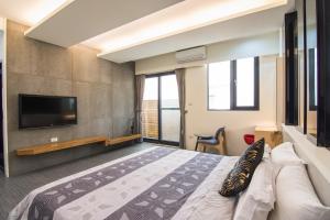 una camera con un grande letto e una TV a schermo piatto di Little SkyLark B&B a Magong