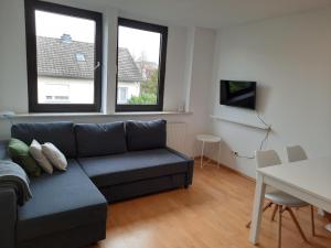 ein Wohnzimmer mit einem Sofa und einem Tisch in der Unterkunft Aurora Apartments in Bad Homburg vor der Höhe
