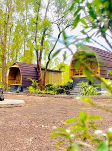 un grande edificio in legno con un fienile in un parco di Bamboo Austin Mountbatur a Baturaja