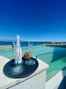 una mesa con dos jarrones de cristal en la parte superior de una piscina en Luxury BEACH VILLA VIR / apartments, en Vir